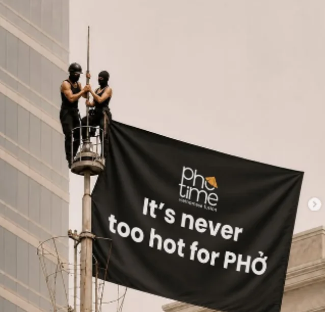 Pho Time post: "It's never too hot for Phở" banner on a pole